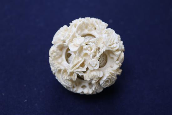 A Chinese ivory concentric puzzle ball and stand, early 20th century, ball 6.7cm, total height 23cm